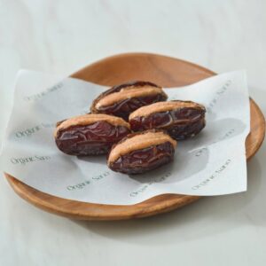 Organic Sano almond sea salt butter stuffed dates on a wooden plate