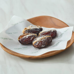 Organic Sano coconut cashew butter stuffed dates on a wooden plate