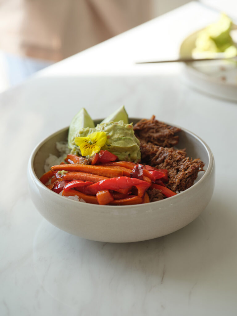 Organic Sano chipotle beef bowl with roasted peppers, avocado and edible flower